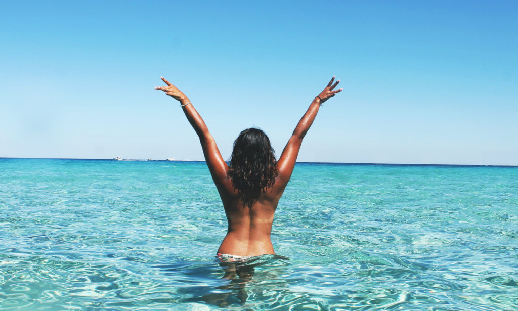 Nude girl in the ocean, enjoying an ecosexual connection to nature