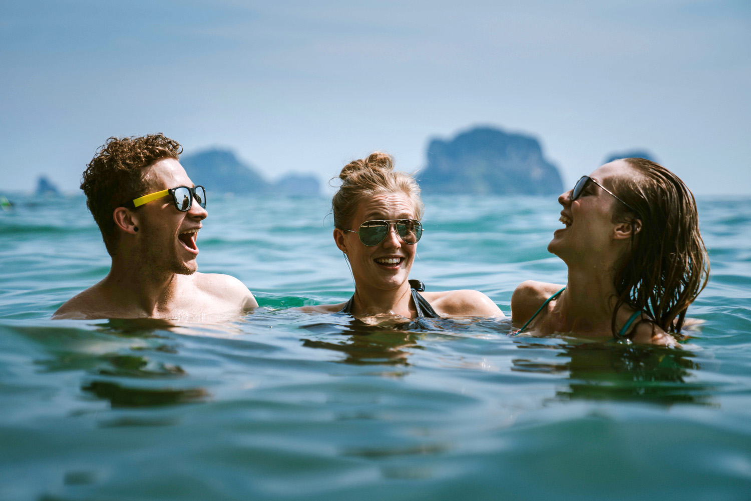 A couple and a unicorn woman having a good time in the ocean