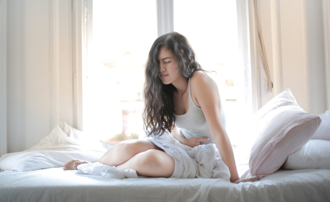 woman in bed dealing with pelvic pain