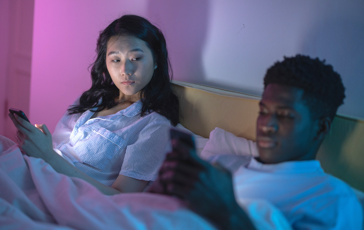 Couple in bed, wondering how to deal with jealousy